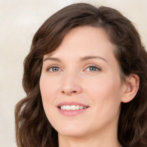 Joyful white young-adult female with long  brown hair and green eyes