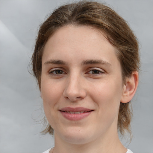 Joyful white young-adult female with medium  brown hair and grey eyes