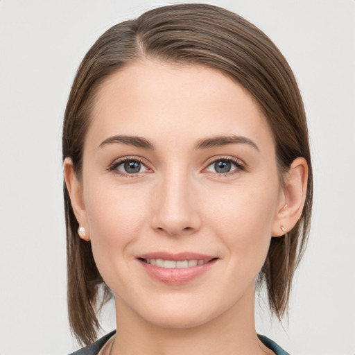 Joyful white young-adult female with medium  brown hair and grey eyes