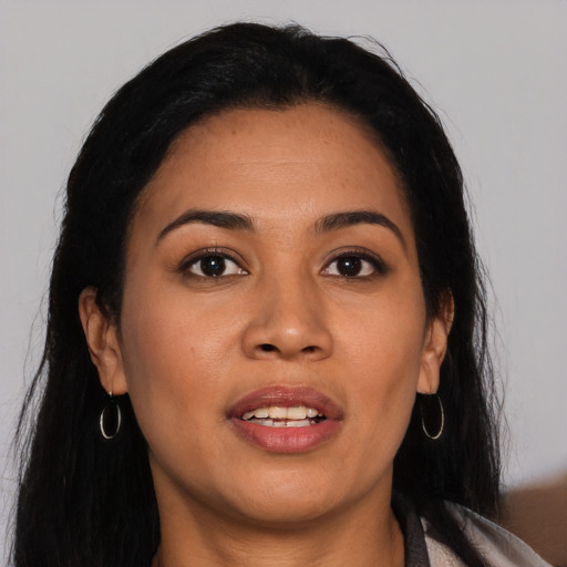 Joyful latino young-adult female with long  brown hair and brown eyes