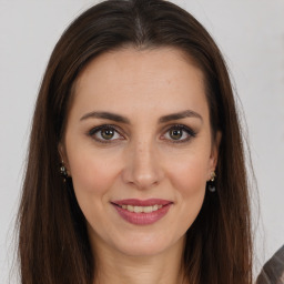 Joyful white young-adult female with long  brown hair and brown eyes