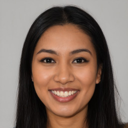 Joyful latino young-adult female with long  brown hair and brown eyes