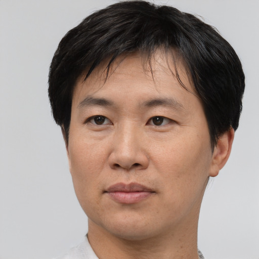 Joyful asian adult male with short  black hair and brown eyes