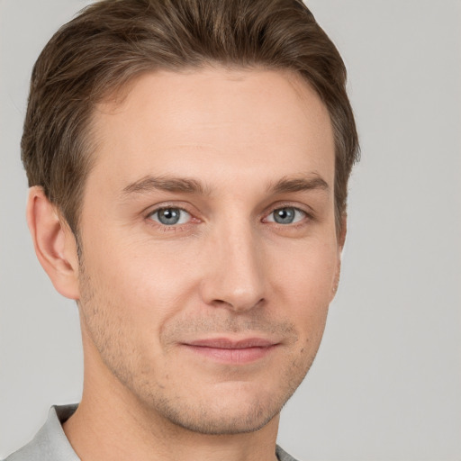 Joyful white young-adult male with short  brown hair and grey eyes