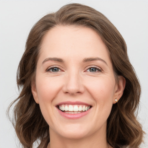 Joyful white young-adult female with medium  brown hair and grey eyes