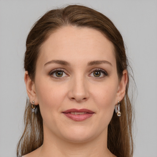 Joyful white young-adult female with medium  brown hair and green eyes