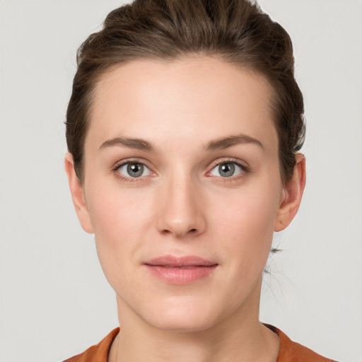 Joyful white young-adult female with short  brown hair and grey eyes