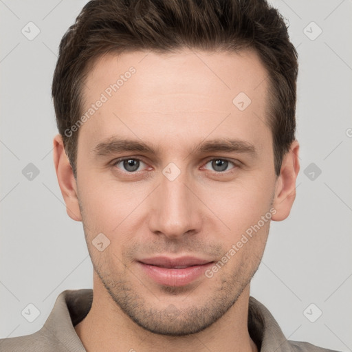 Joyful white young-adult male with short  brown hair and grey eyes