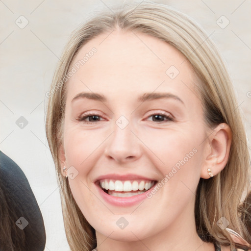 Joyful white young-adult female with long  brown hair and blue eyes