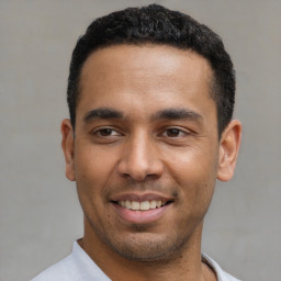 Joyful latino young-adult male with short  black hair and brown eyes