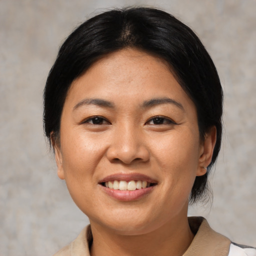 Joyful asian young-adult female with medium  black hair and brown eyes