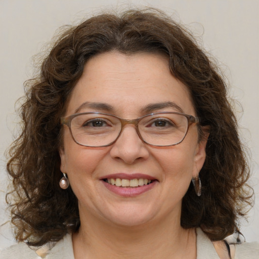 Joyful white adult female with medium  brown hair and blue eyes