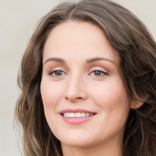 Joyful white young-adult female with long  brown hair and green eyes