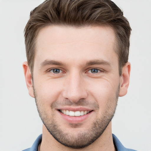 Joyful white young-adult male with short  brown hair and grey eyes