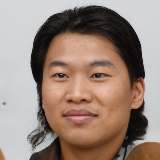 Joyful asian young-adult male with medium  black hair and brown eyes