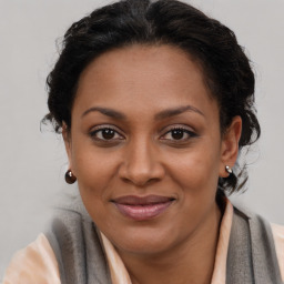 Joyful black adult female with long  brown hair and brown eyes