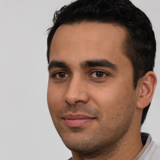 Joyful white young-adult male with short  black hair and brown eyes