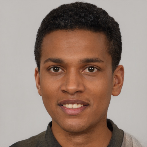 Joyful black young-adult male with short  black hair and brown eyes