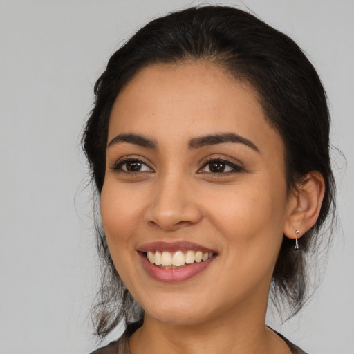 Joyful latino young-adult female with medium  black hair and brown eyes