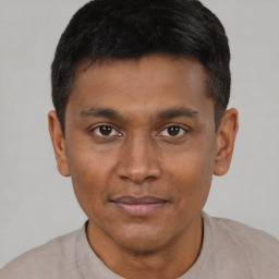 Joyful black young-adult male with short  brown hair and brown eyes