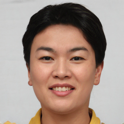 Joyful asian young-adult female with short  black hair and brown eyes