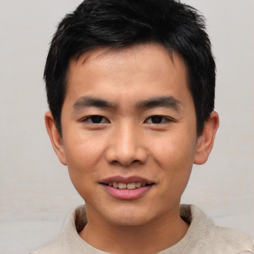 Joyful asian young-adult male with short  black hair and brown eyes
