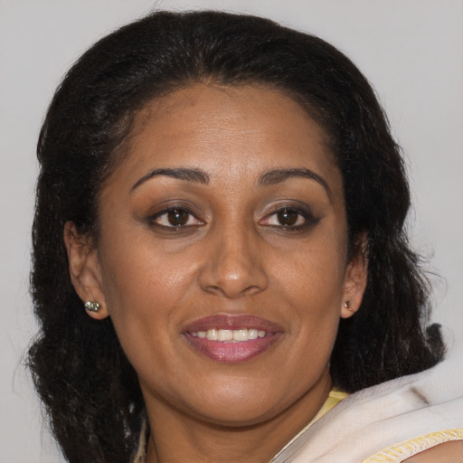 Joyful latino adult female with medium  brown hair and brown eyes