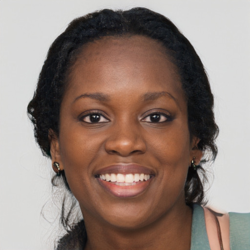 Joyful black young-adult female with long  black hair and brown eyes