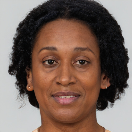 Joyful black adult female with short  black hair and brown eyes