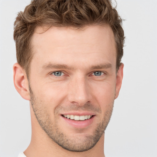 Joyful white young-adult male with short  brown hair and grey eyes