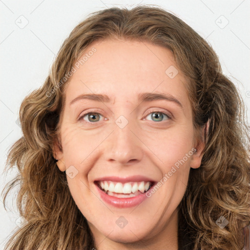 Joyful white young-adult female with long  brown hair and green eyes