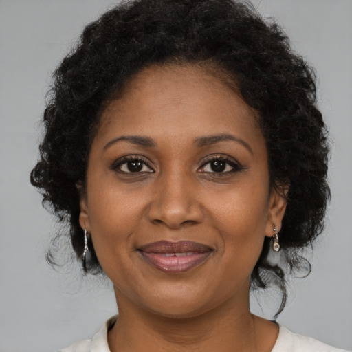 Joyful black adult female with medium  brown hair and brown eyes