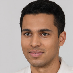 Joyful latino young-adult male with short  black hair and brown eyes