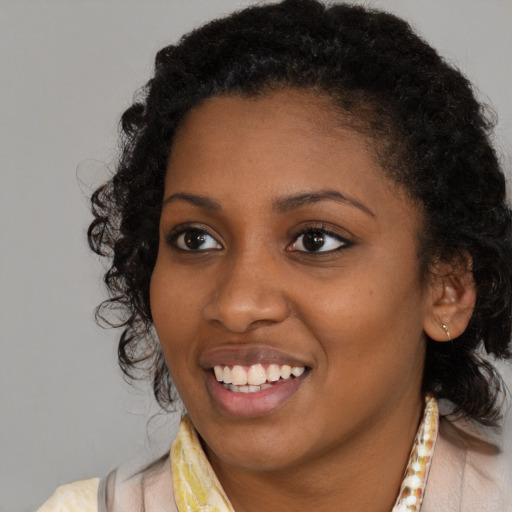 Joyful black young-adult female with medium  black hair and brown eyes