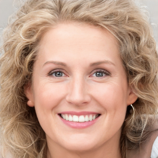 Joyful white young-adult female with long  brown hair and blue eyes