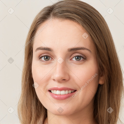 Joyful white young-adult female with long  brown hair and green eyes