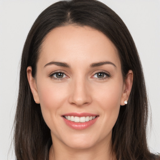 Joyful white young-adult female with long  brown hair and brown eyes