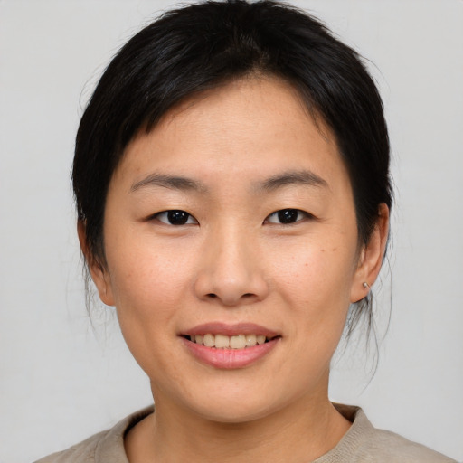 Joyful asian young-adult female with medium  brown hair and brown eyes