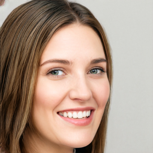 Joyful white young-adult female with long  brown hair and green eyes