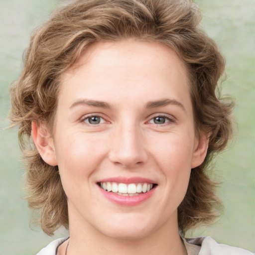 Joyful white young-adult female with medium  brown hair and blue eyes