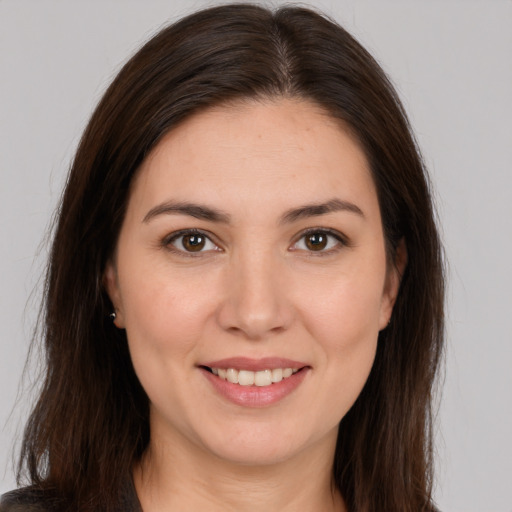 Joyful white young-adult female with long  brown hair and brown eyes