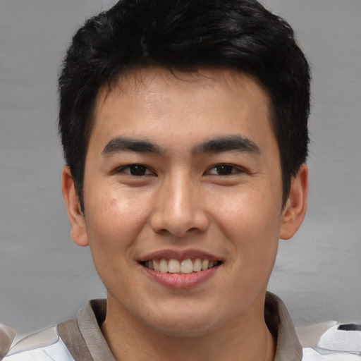 Joyful asian young-adult male with short  brown hair and brown eyes