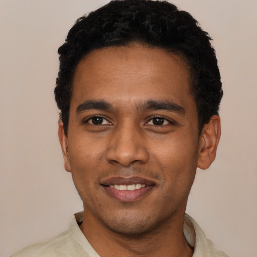 Joyful black young-adult male with short  black hair and brown eyes