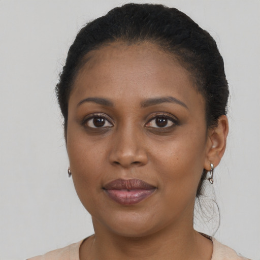 Joyful black young-adult female with long  brown hair and brown eyes