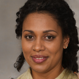 Joyful black adult female with medium  brown hair and brown eyes