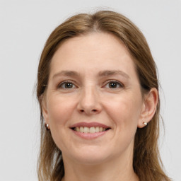 Joyful white adult female with long  brown hair and grey eyes