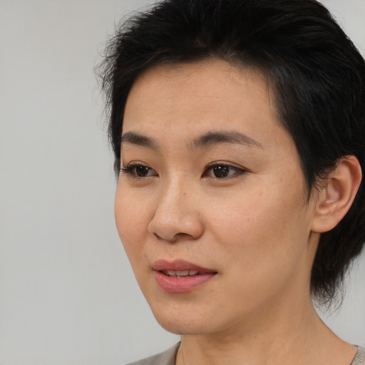 Joyful asian young-adult female with medium  black hair and brown eyes
