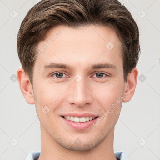 Joyful white young-adult male with short  brown hair and grey eyes