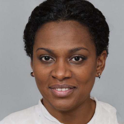 Joyful black young-adult female with short  black hair and brown eyes