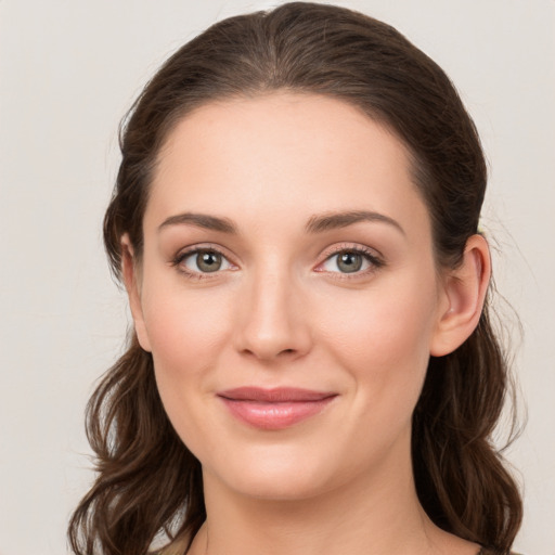 Joyful white young-adult female with long  brown hair and green eyes